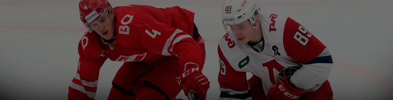 На изображении два хоккеиста в красной и белой форме склонились над шайбой на льду. Один из них в ярко-красной форме с номером 4, другой в белой форме с красными акцентами и номером 89